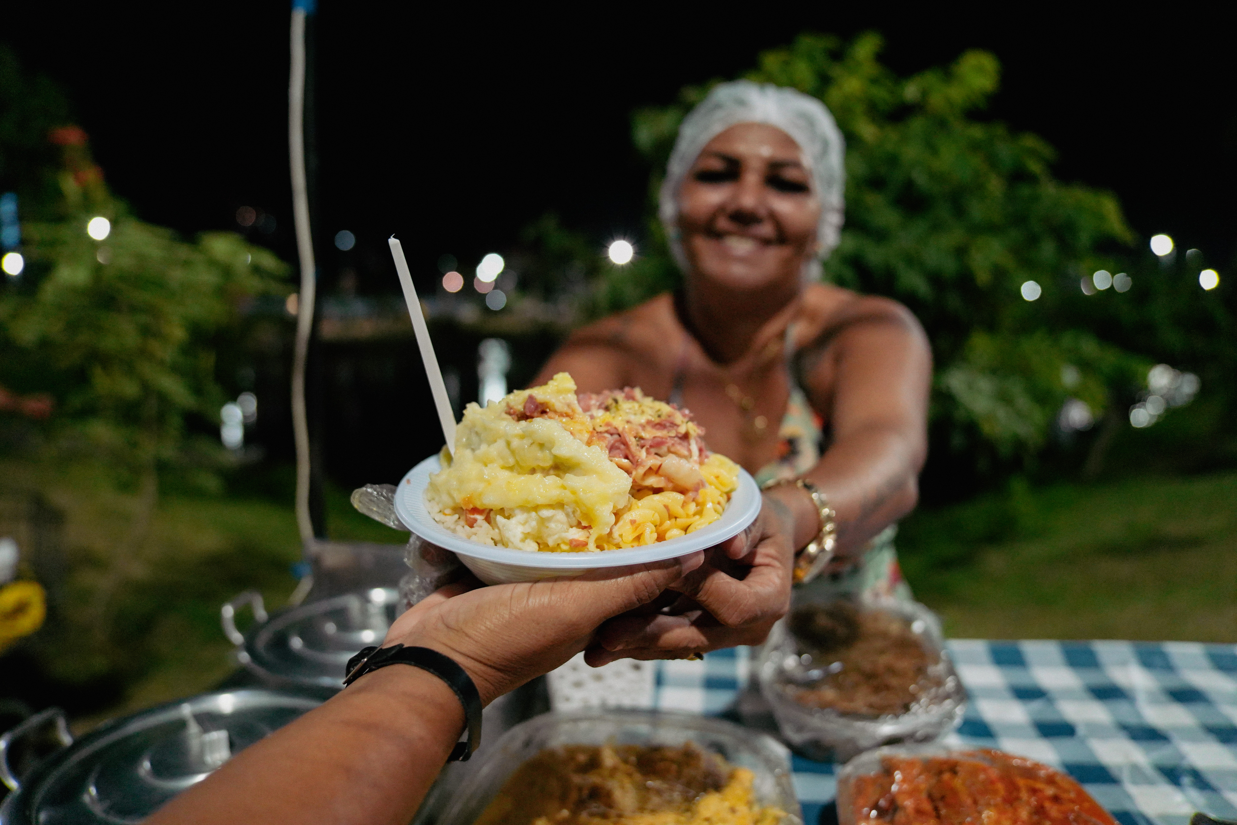 mulher oferece pratinho de vatapá